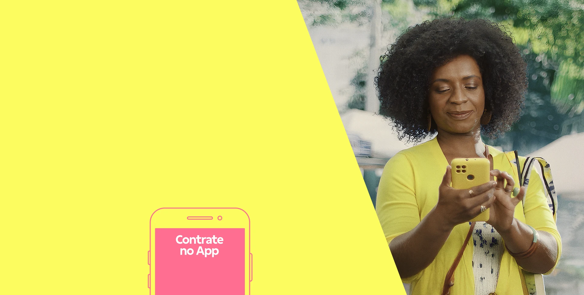 Mulher negra de blusa amarela olhando para o celular e digitando.