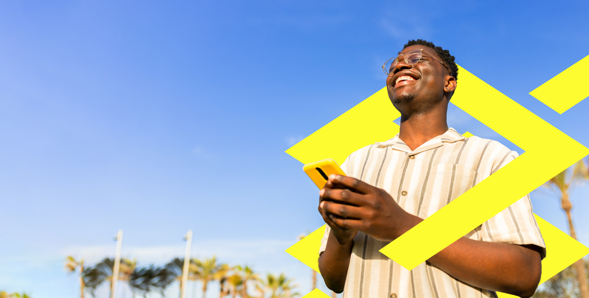 Homem negro, jovem, usando camisa listrada de botão, de óculos, segurando o celular com as duas mãos e sorrindo. A imagem apresenta o texto: Vem ser cliente. Tenha uma conta corrente completa, com abertura 100% digital, direto no App BB. A imagem também contém um QRCode com o texto Aponte a câmera do seu celular para o código ao lado para baixar o App BB.